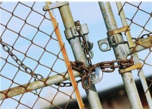 chain link fence gate locked with a chain and padlock