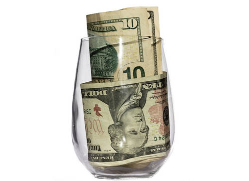 Glass with money bills in it.