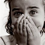 Scared girl with her hands over her mouth