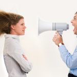 man yelling criticism at a woman through a bullhorn