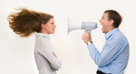 man yelling criticism at a woman through a bullhorn