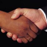 People of different skin color shaking hands.