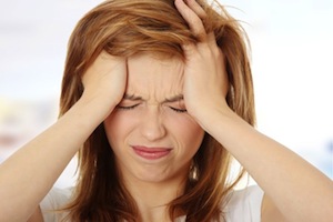 woman with her hands to her face looking stressed out