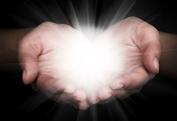Hands holding light representing a miracle.